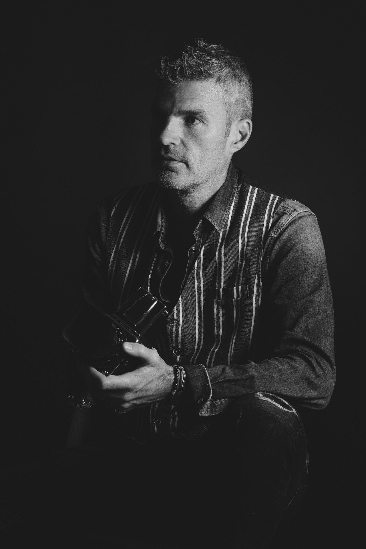 Ritratto in bianco e nero di Alessandro Lazzarin con una fotocamera medio formato tra le mani