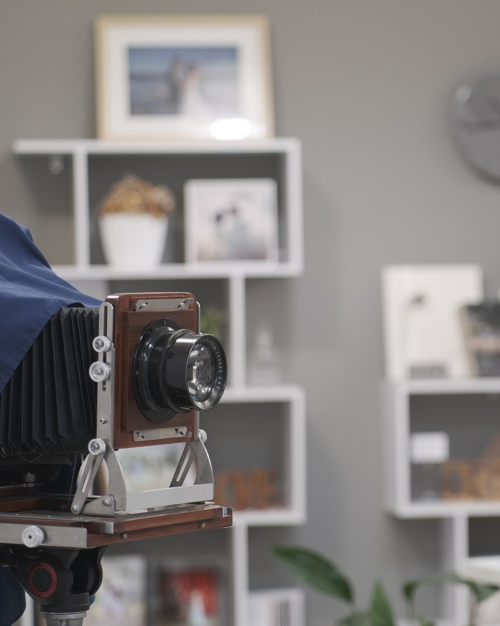 Fotocamera a banco ottico d'epoca su cavalletto, con panno blu e obiettivo a soffietto